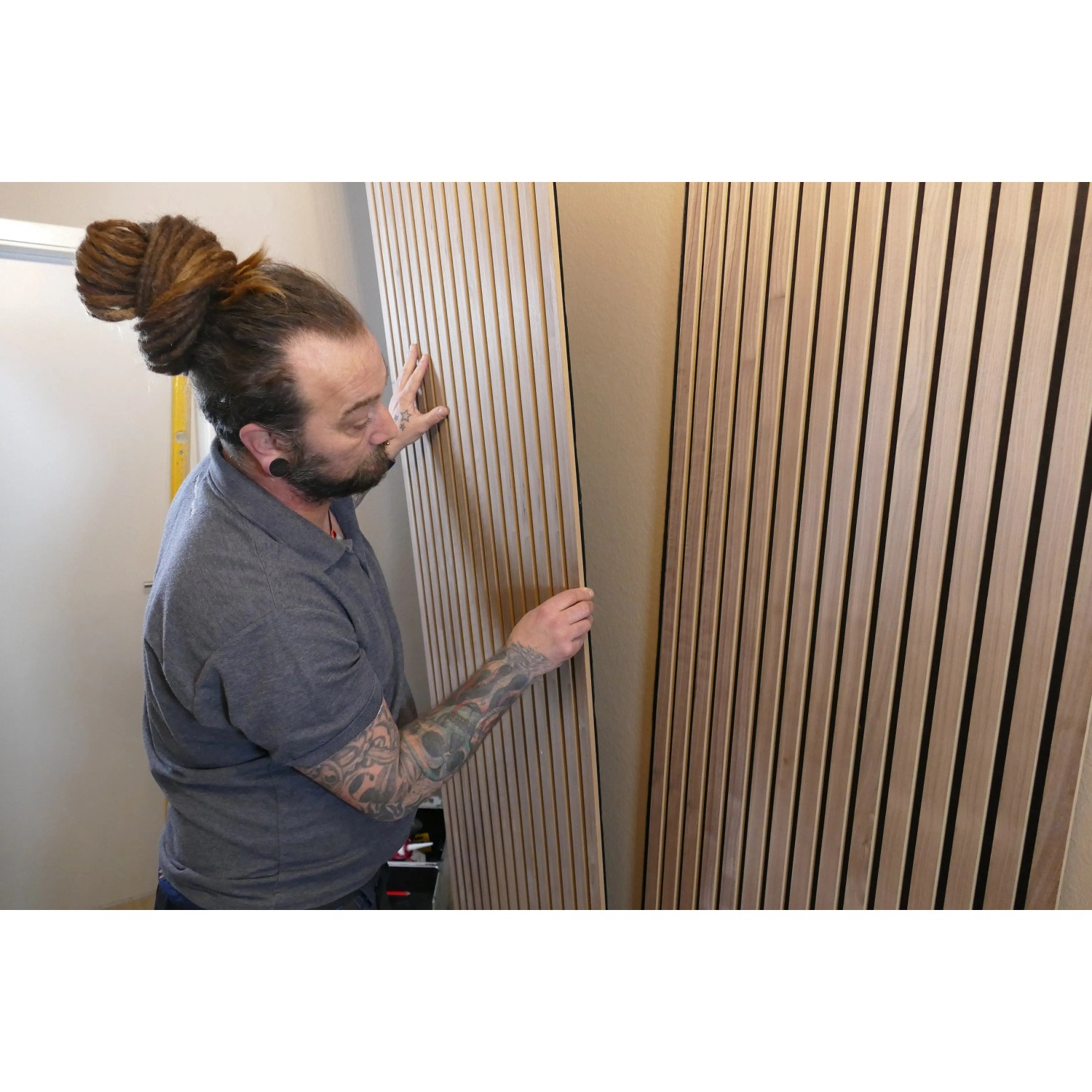 Anwender montiert Holzpaneele mit Soudal High Tack Kraftkleber an der Wand.
