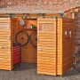 Transparente Acryl-Trapezplatte als Bedachung für einen Holzschuppen mit Fahrrädern und Werkzeug.