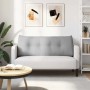 Langes, wolkengraues Rückenkissen mit gesteppten Knöpfen auf weißem Sofa im Wohnzimmer.