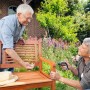 Paar montiert Holzbank im Garten mit Bosch IXO 5 Akkuschrauber.