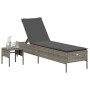 Graue Poly Rattan Sonnenliege mit Tisch und Auflage für den Garten.