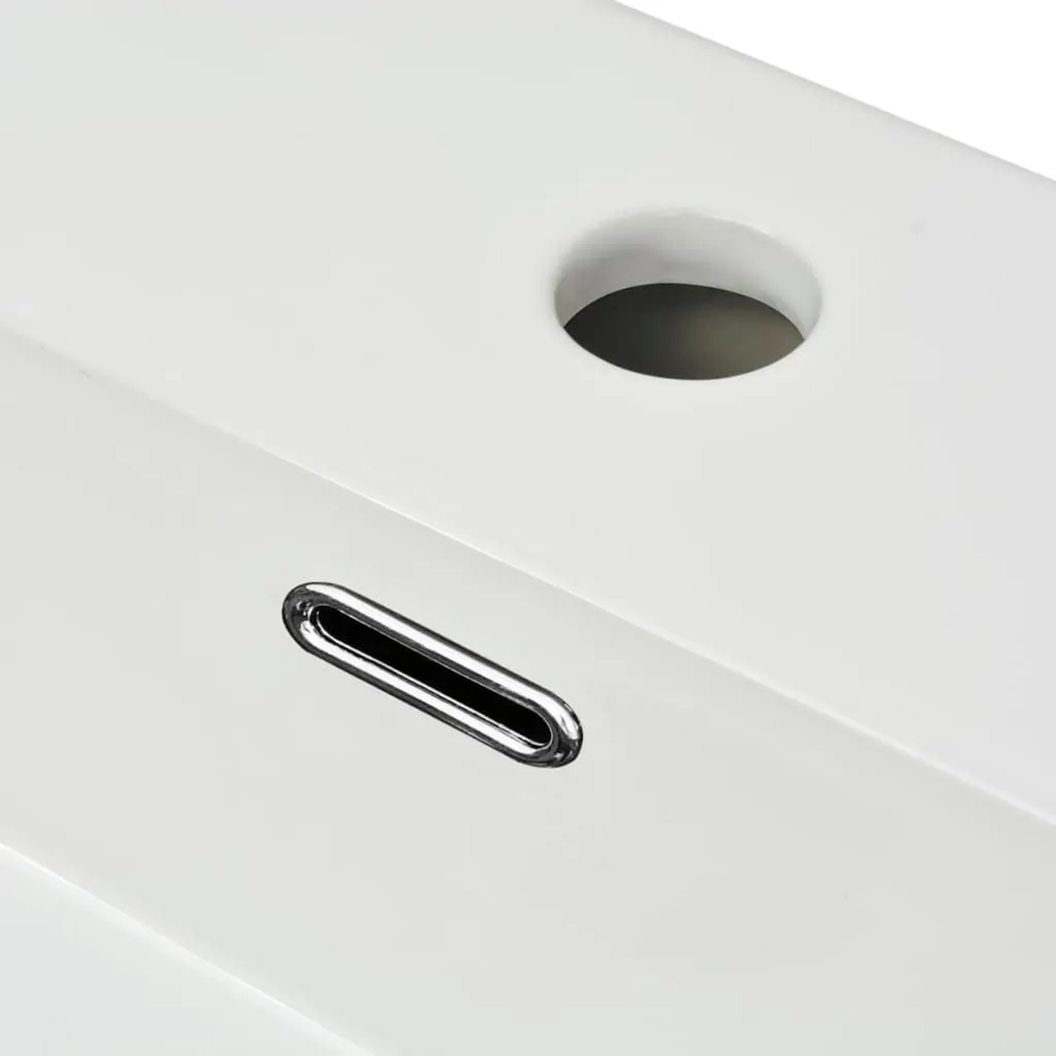 Detailaufnahme: Weißes Keramik Waschbecken mit Hahnloch und Überlauf.