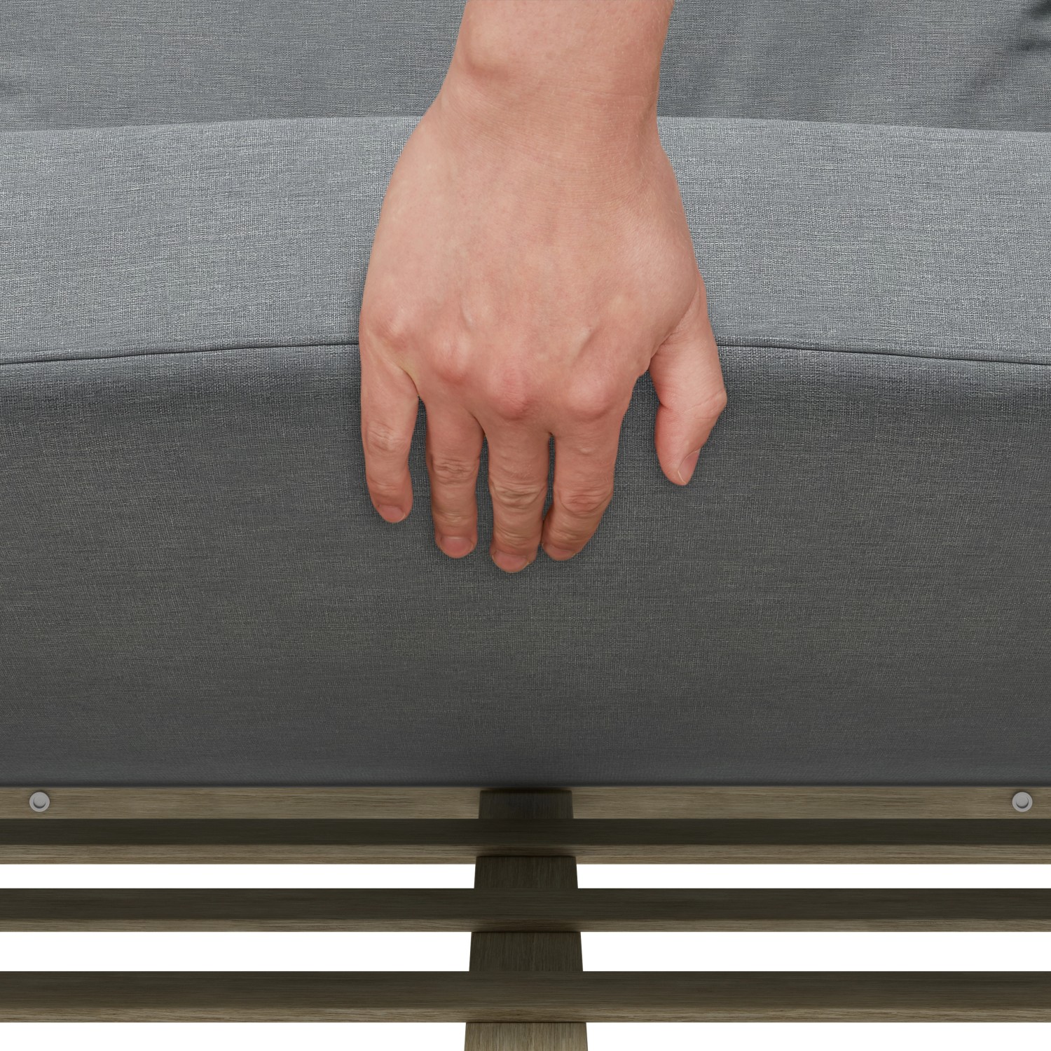 Detailaufnahme: Hand drückt auf graues Sitzkissen des Lounge-Sets Calora aus Rattangeflecht.