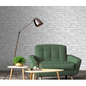 Graue Erismann Vliestapete in Steinoptik an Wand hinter Sessel und Lampe.