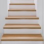 Goldenes, selbstklebendes KARAT Stufenkantenprofil Integral Form L auf Holztreppe.