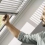 Velux Jalousie, silber gebürstet, manuell bedienbar am Dachfenster.