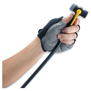 Hand mit Handschuh hält den gelben TwinHead Ventilanschluss einer Topeak Luftpumpe mit schwarzem Schlauch.