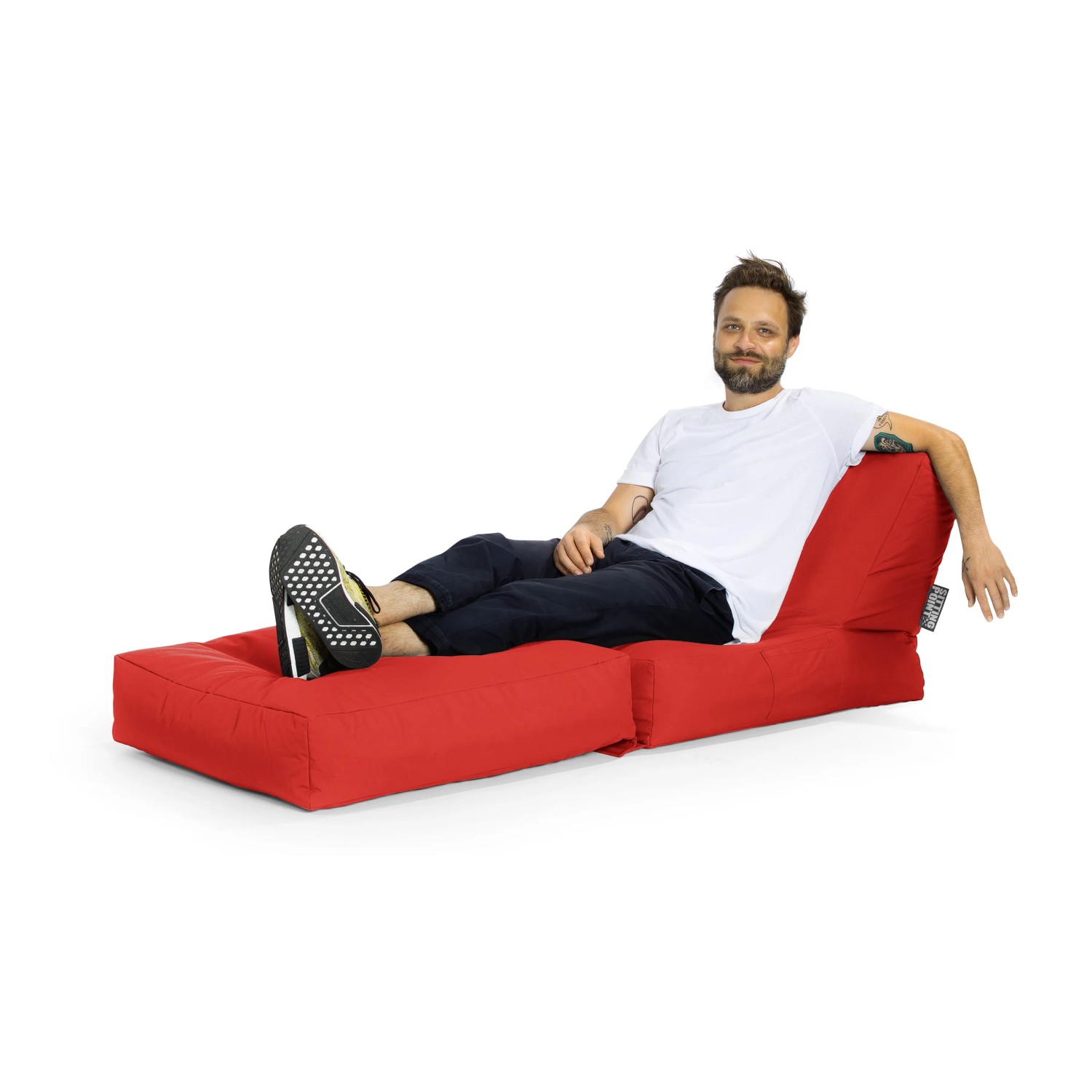 Mann entspannt auf rotem Sitting Point Sessel Twist Scuba. Bequemer Sitzsack für Indoor & Outdoor.