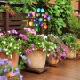 Buntes Relaxdays Windrad aus Eisen mit zwei Rädern und Erdspieß, in Blumenbeet auf Terrasse. Dekorative Gartenfigur.