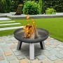 Buschbeck Feuerschale XS (Ø 55cm) aus Eisen mit brennendem Holz im Garten.