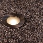 Lutec LED-Bodeneinbaustrahler Strata im Kiesbett. Edelstahl-Design mit warmweißem Licht.