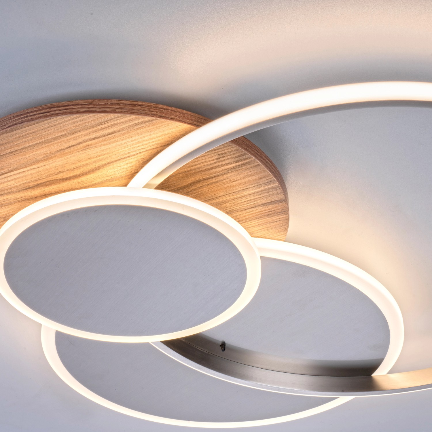 Moderne LED-Deckenleuchte Palma mit Holzdekor und silberfarbenen Ringen für Wohnräume.