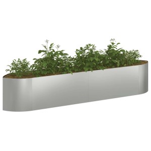 Langes, silbernes Hochbeet aus verzinktem Stahl mit abgerundeten Ecken, bepflanzt mit grünen Pflanzen.