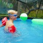 EXIT Pool mit Abdeckung 300x200cm: Kind mit Schwimmflügeln im Pool unter der Poolabdeckung.
