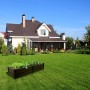 Anthrazitfarbenes KHW Hochbeet Demeter L (196 l) im Garten vor einem Haus.