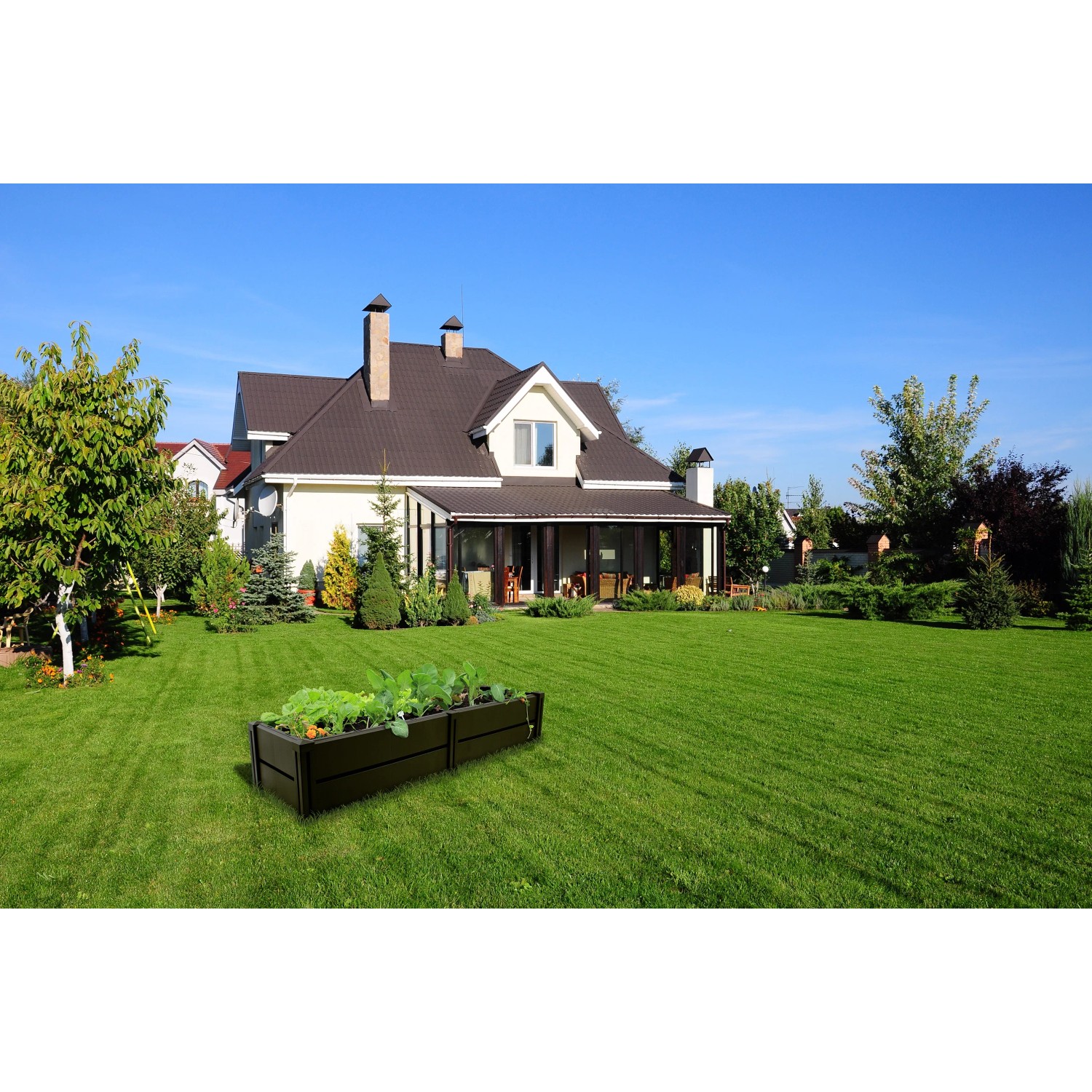 Anthrazitfarbenes KHW Hochbeet Demeter L (196 l) im Garten vor einem Haus.
