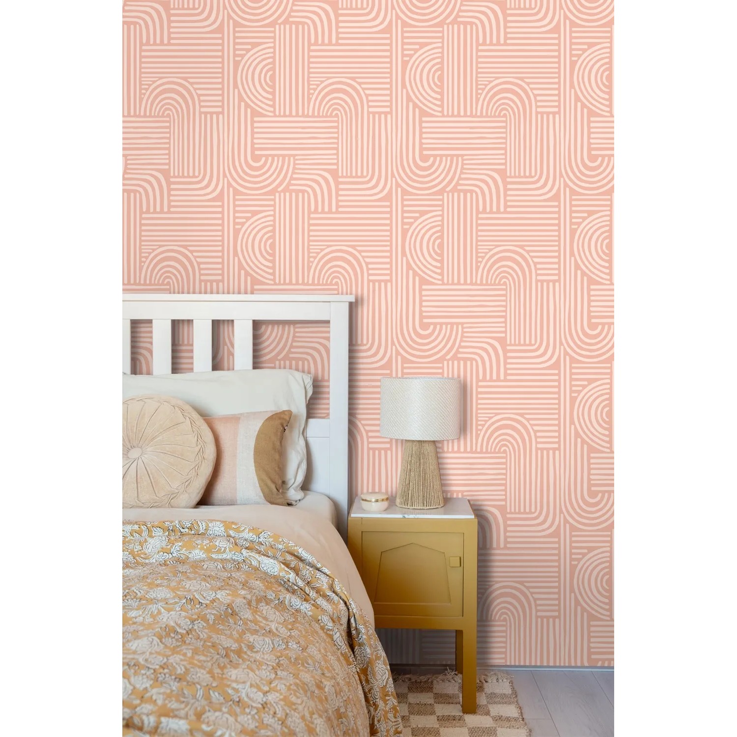 Rosa Vliestapete mit modernem 3D-Muster an einer Schlafzimmerwand, neben weißem Bett und Nachttisch.