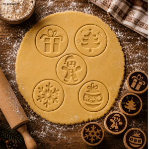 Fünf Holz Teigstempel mit Weihnachtsmotiven wie Tannenbaum, Schneemann und Geschenk prägen Keksteig. Ideal für Backen und Basteln.