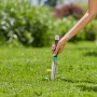 Gardena EcoLine Unkrautstecher im Einsatz gegen Löwenzahn im grünen Rasen.