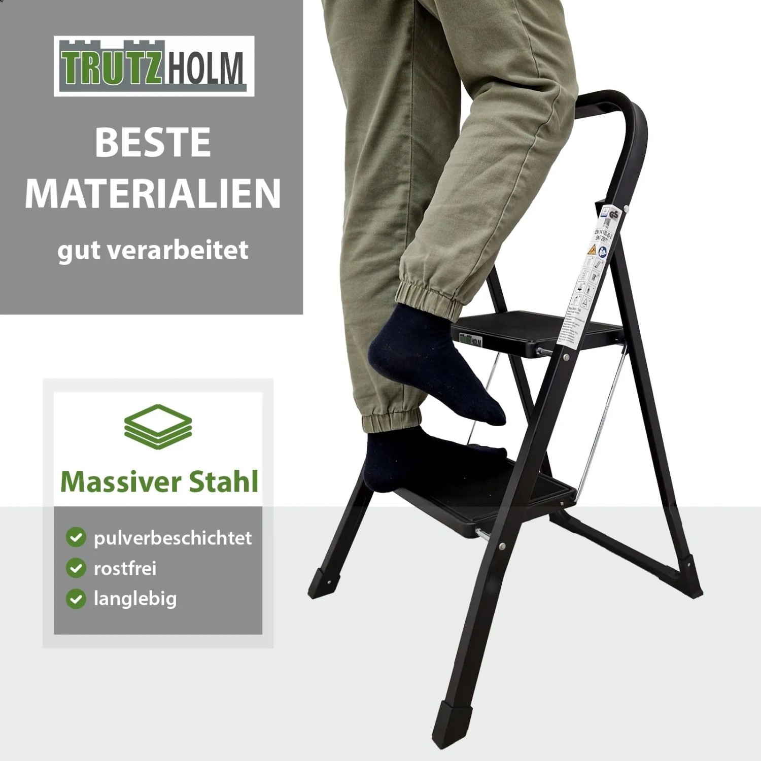 TRUTZHOLM Trittleiter mit 2 Stufen, klappbar, schwarz, mit Person auf der obersten Stufe.