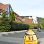 3D-Straßenwarnschild "Spielende Kinder" in Orange-Schwarz für mehr Sicherheit im Straßenverkehr.