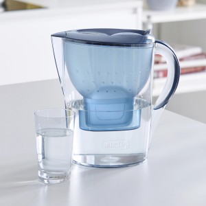 Brita Marella Wasserfilter-Kanne blau mit 3 Maxtra+ Kartuschen und Glas Wasser.