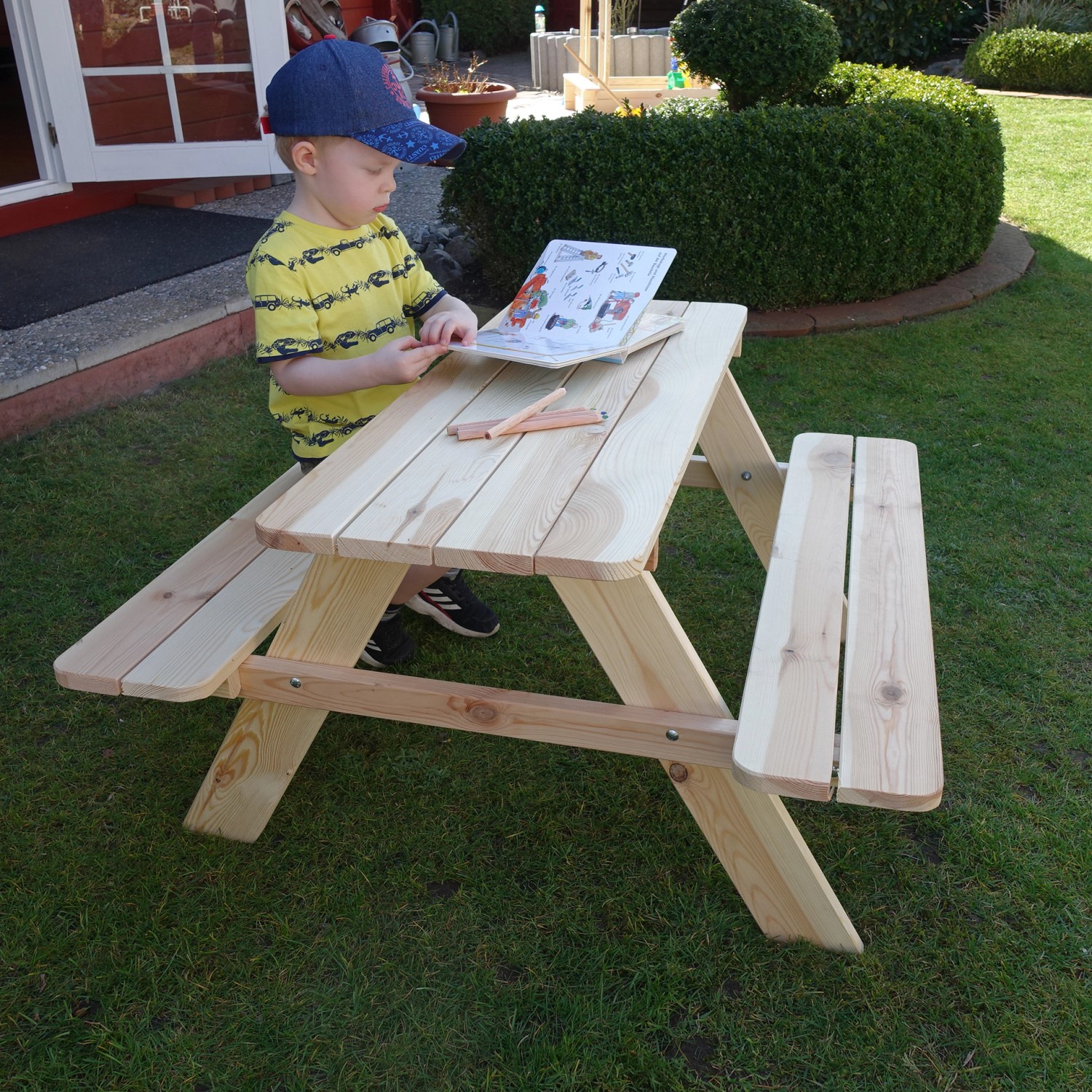 Promadino Limobank für Kinder aus Kiefernholz, naturbelassen, mit Kind beim Malen im Garten.