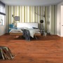 Verlegtes Laminat Comfort Pinie Mokka Dunkel 7 mm im Schlafzimmer mit Bett und Kommode.