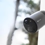 Ezviz Akku-Überwachungskamera BC1C mit Solarmodul, montiert an einer weißen Wand.