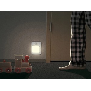 Warmweißes LED-Nachtlicht mit Bewegungsmelder an der Wand, daneben ein Spielzeugzug und eine Person.