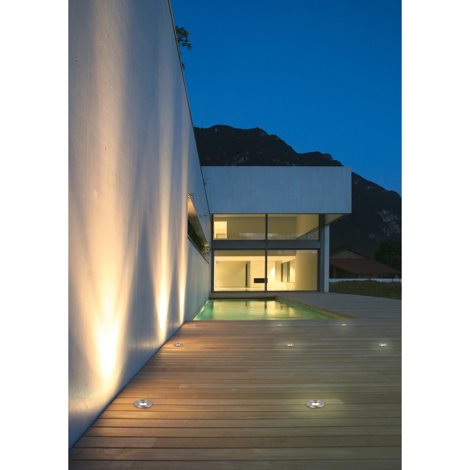 Eingebaute Trio LED-Bodeneinbaustrahler Belaja, Nickel matt, beleuchten eine Terrasse.