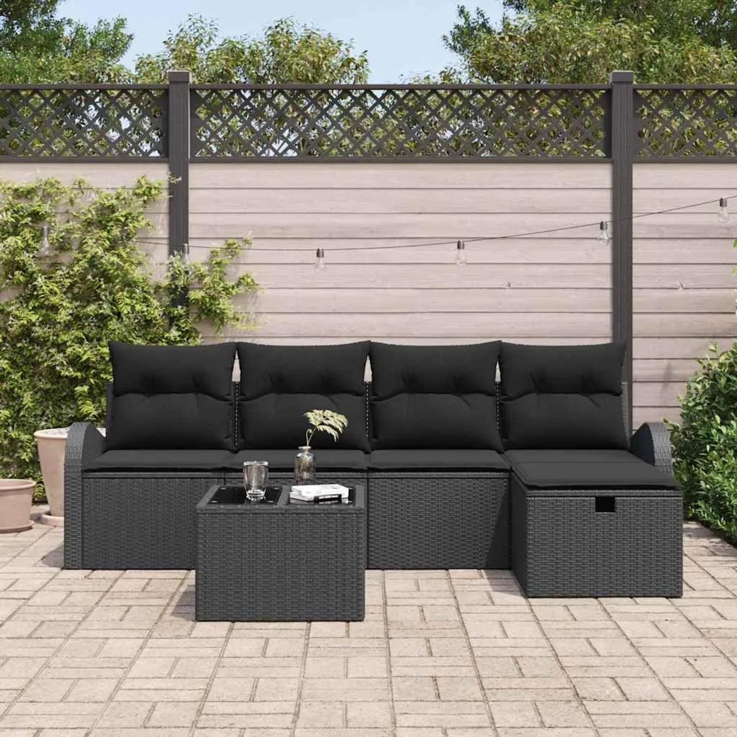 Schwarzes 6-teiliges Garten-Sofa-Set aus Poly Rattan mit Tisch und Kissen.