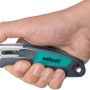 Hand hält wolfcraft Profi-Dual-Sicherheitsmesser mit Trapezklinge, silber/grün.
