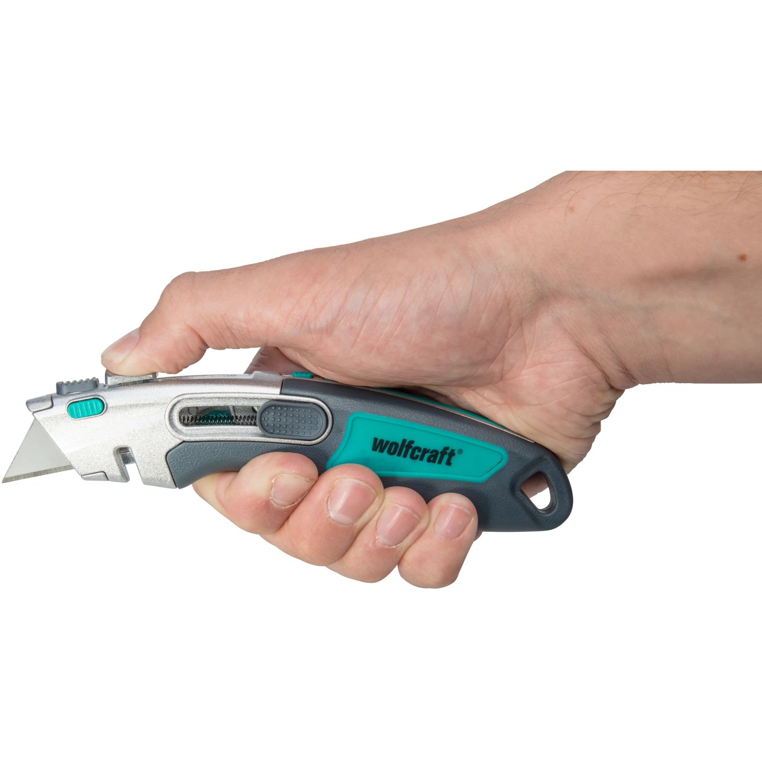 Hand hält wolfcraft Profi-Dual-Sicherheitsmesser mit Trapezklinge, silber/grün.