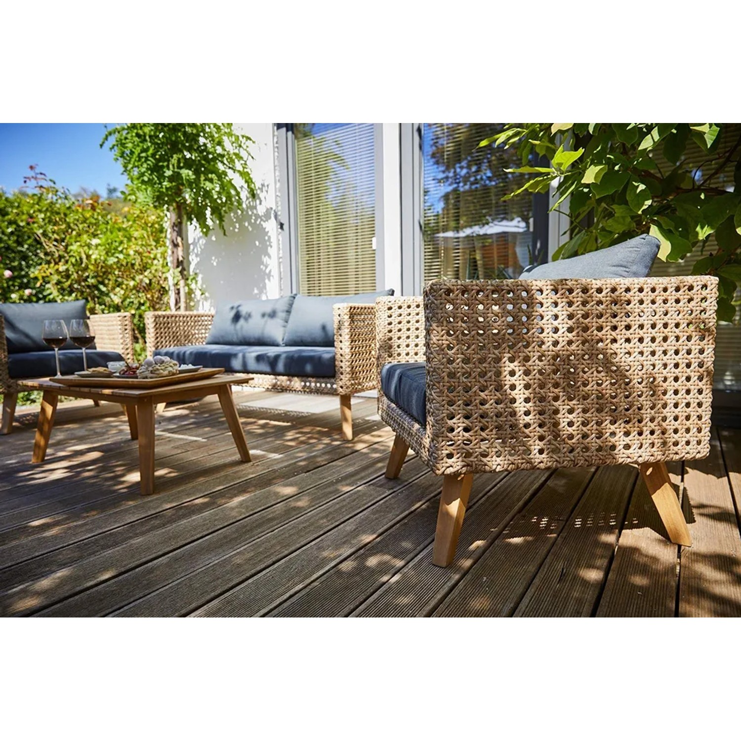 4-teiliges Lounge-Set Junee aus Polyrattan in Natur mit anthrazitfarbenen Auflagen und Holztisch.