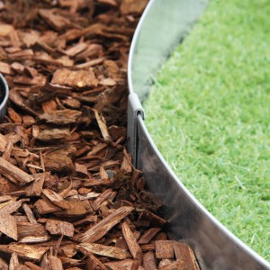 Bellissa Bodenanker an Rasenkante aus Metall, fixiert Beet mit Rindenmulch und Rasen.