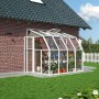 Weißes Palram Canopia Gewächshaus Sun Room (262x201 cm) am Haus mit Pflanzen.