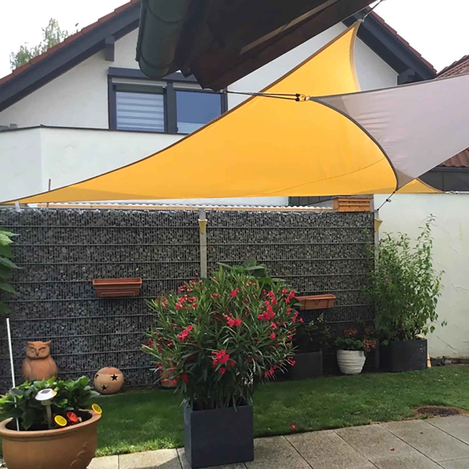 Sandfarbenes Toldoro Dreieck-Sonnensegel (4x4x5,6m) spendet Schatten im Garten.