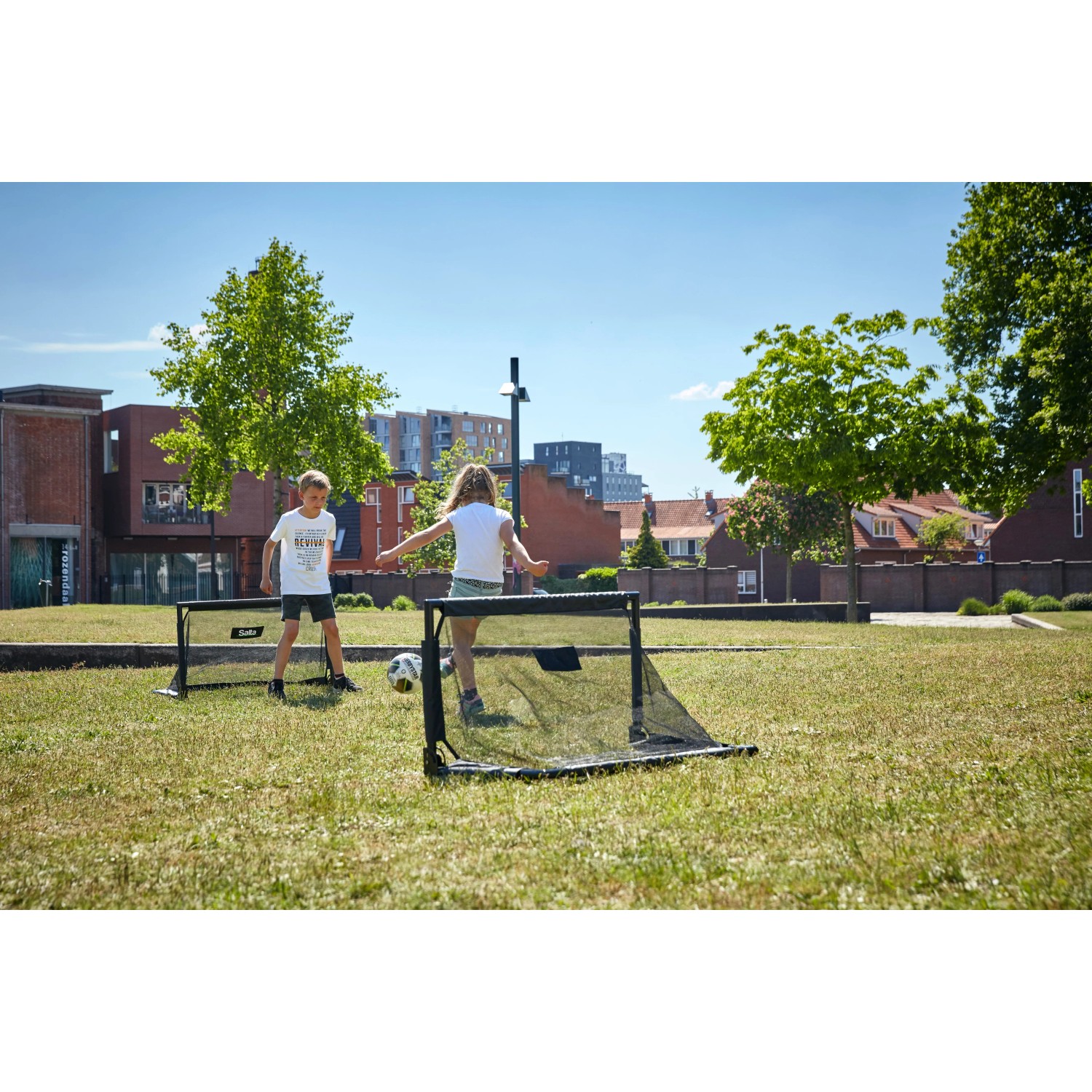 Salta Fußballtor Set Challenge, 2 Tore (100x60x60cm) im Garten mit spielenden Kindern.