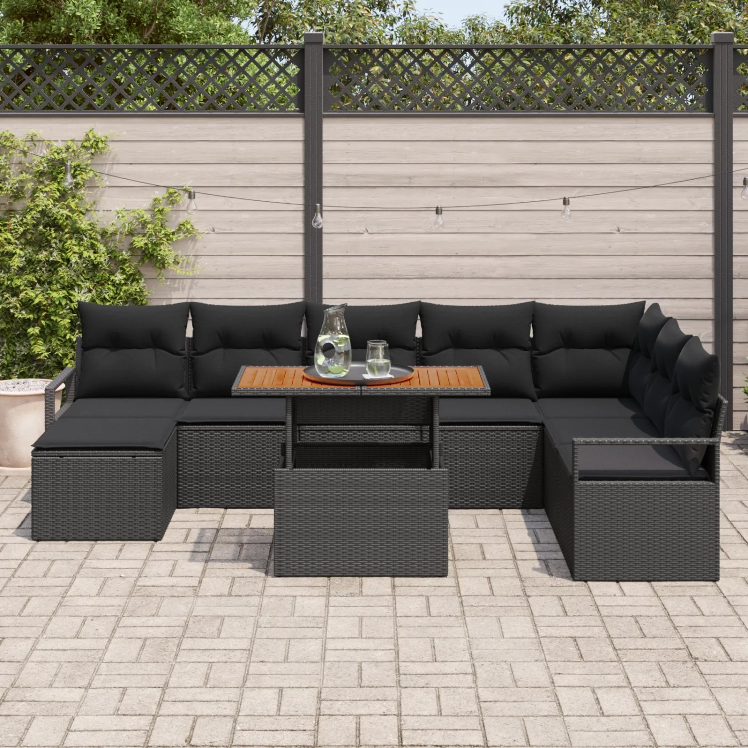 Schwarzes 9-teiliges Garten-Sofa Set aus Poly Rattan mit Tisch und Kissen.