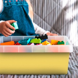 Gelbe Venilia Klebefolie (45x200cm) mit Spielzeug in durchsichtiger Box, ideal für DIY-Projekte.