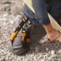 Fiskars Handwerkermesser mit Holster und Messerschärfer im Einsatz beim Bearbeiten eines Holzstücks.