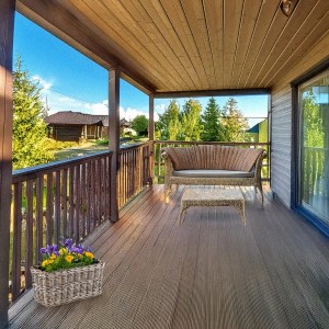 Kobolo Blumenbank LAURO, Rattan Pflanzkorb in Grau mit Blumen auf einer Terrasse.