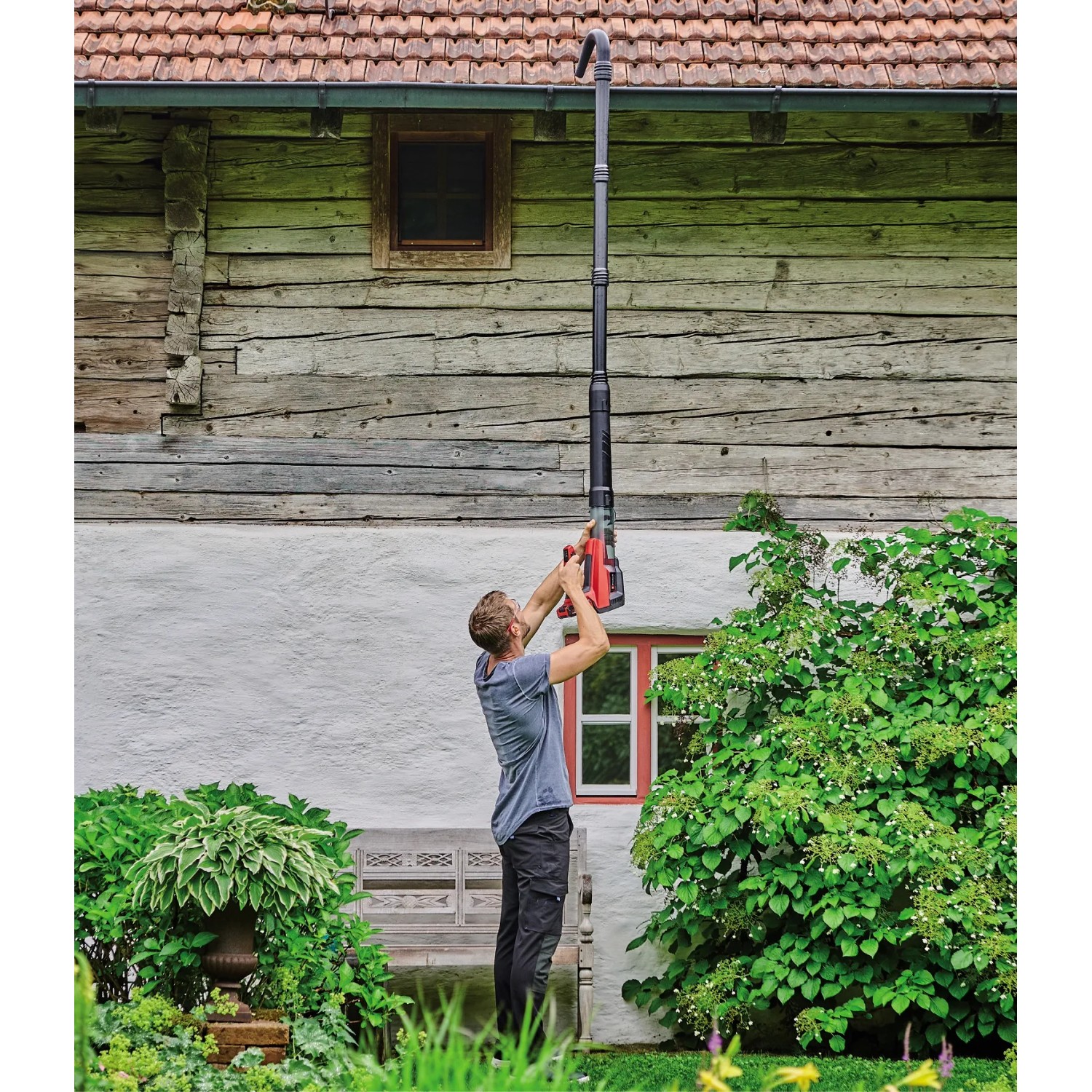 Mann reinigt Dachrinne mit Einhell Akku-Laubbläser GP-LB 18/200 Li. Laubgebläse mit Dachrinnen-Set.