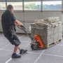 Mann zieht Palette mit Steinen auf Scorprotect Vliesfaserplatten zum Schutz des Bodens.