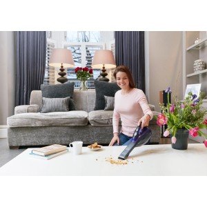 Frau nutzt Black+Decker Akku-Handstaubsauger Pet zum Krümel saugen.