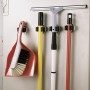Gerätehalter-Set mit Besen, Schrubber und Kehrblech an der Wand.