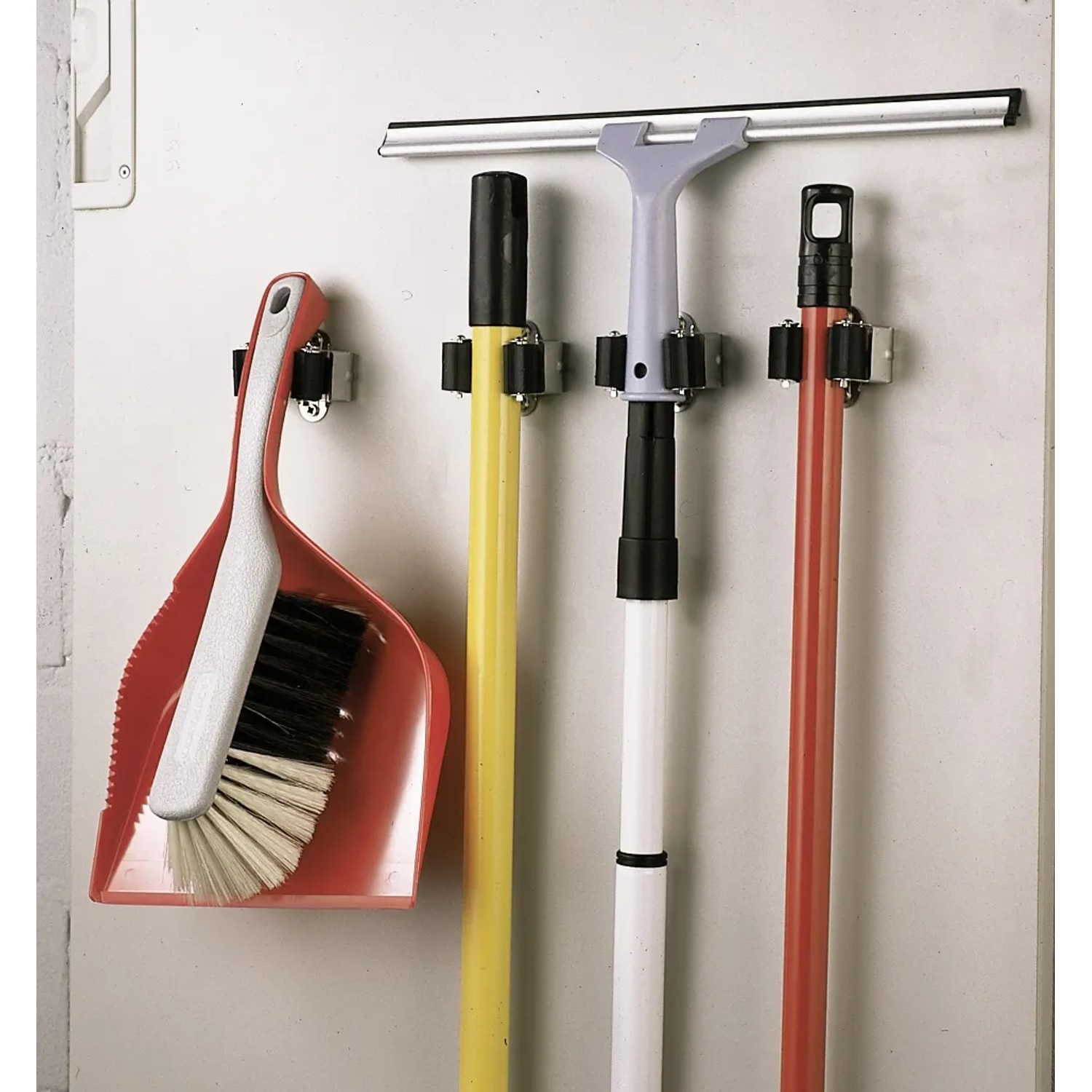 Gerätehalter-Set mit Besen, Schrubber und Kehrblech an der Wand.