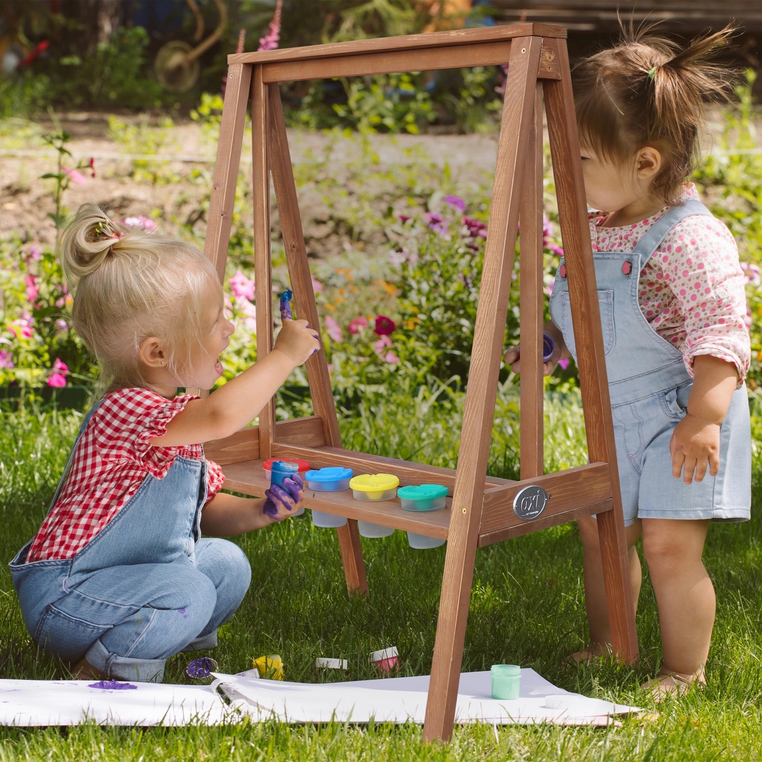 Axi Kinderstaffelei Eric Dunkelbraun mit zwei spielenden Kindern im Garten.