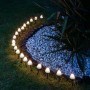Marelida LED Solar Lichterkette mit 10 leuchtenden Mini Pilzen als Gartenstecker im dunklen Gartenbeet.